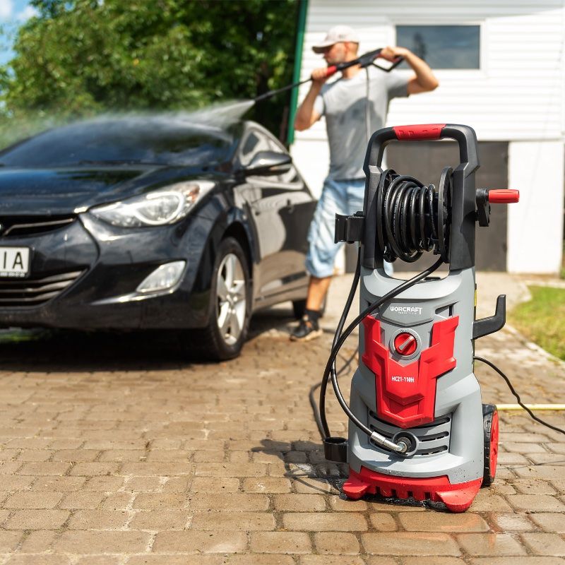 Мойка высокого давления WORCRAFT HC21-110H рядом с автомобилем.