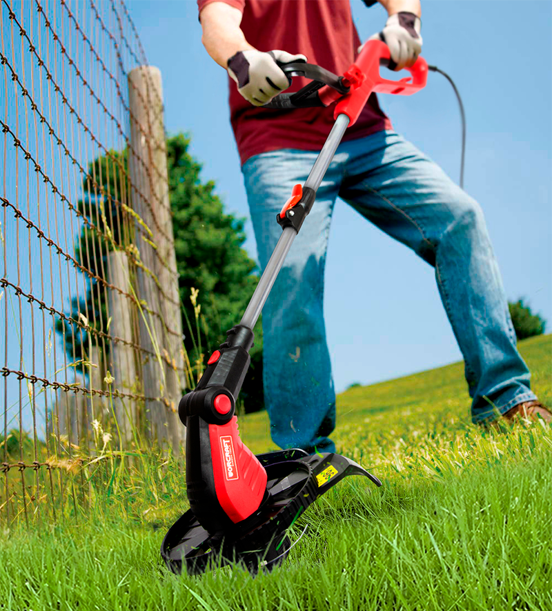 Работа с электрическим триммером WORCRAFT EGT07-300 вдоль забора на газоне.
