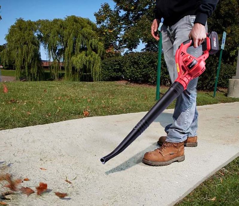 Работа с WORCRAFT CLB-S20Li на улице — оператор сдувает листья с дорожки.
