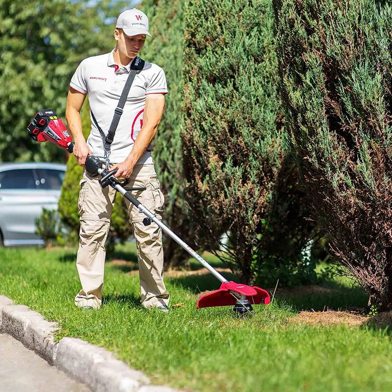 Мужчина косит траву триммером WORCRAFT