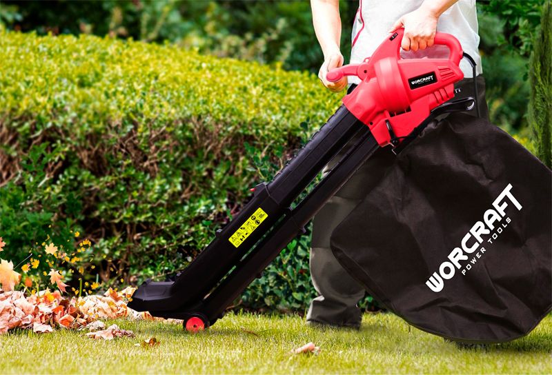 Садовый пылесос WORCRAFT VB30‑45 в работе, уборка листвы с газона.