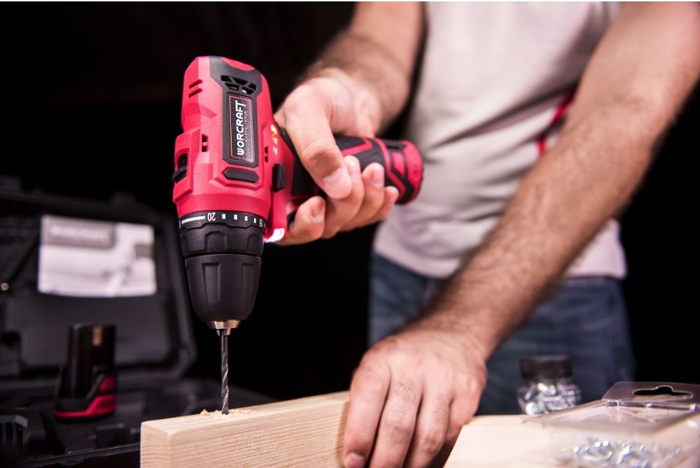 Мужчина сверлит отверстие в деревянной доске аккумуляторным шуруповёртом WORCRAFT CD-12LiA.