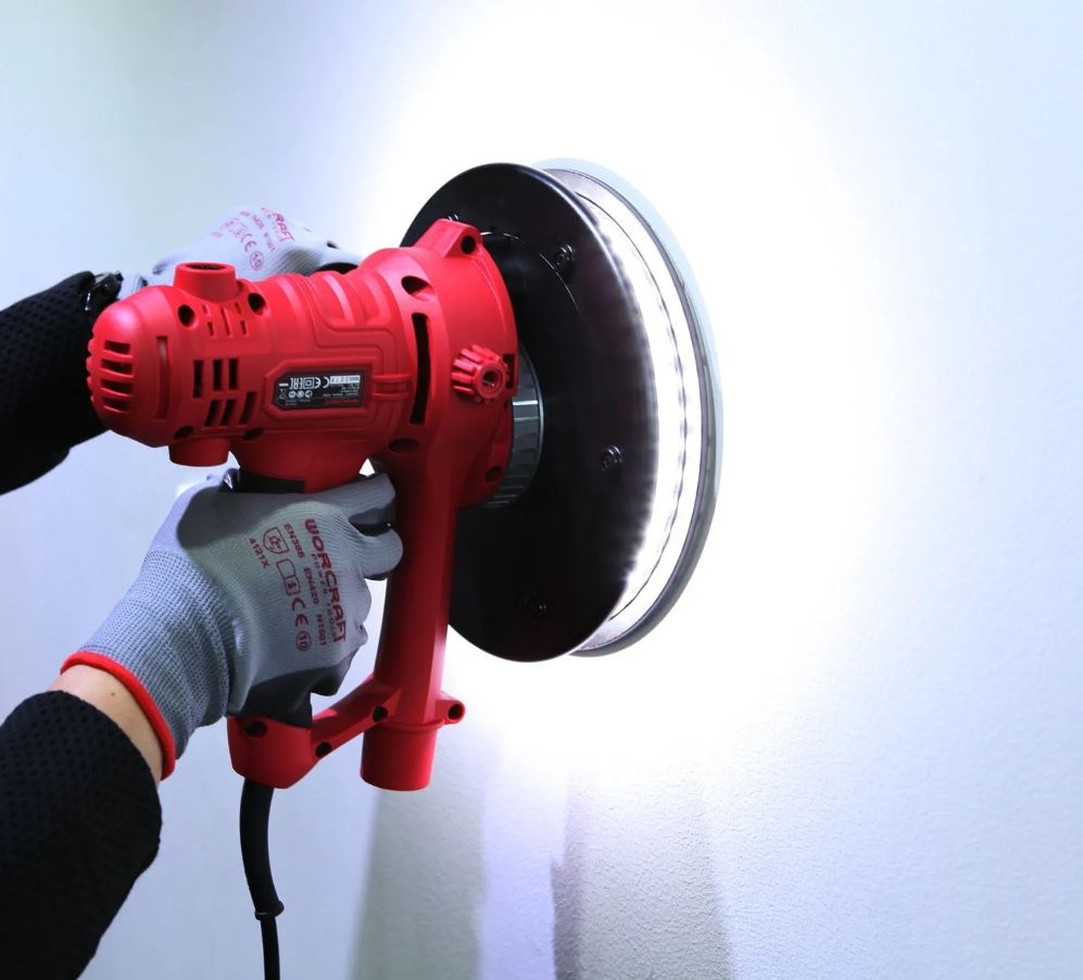 Шлифовальная машина для стен WORCRAFT DS08-180 в работе — обработка поверхности с подсветкой.