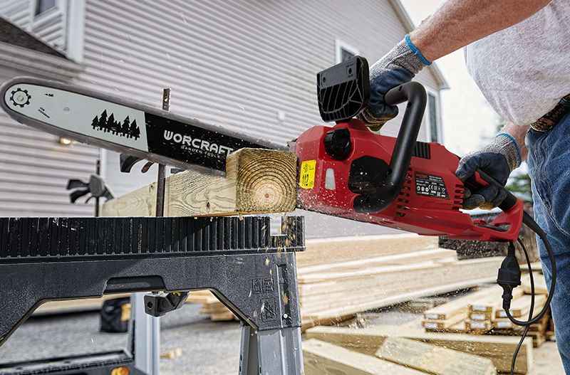 Электропила WORCRAFT WCE-2816 S в процессе распила деревянного бруса на строительной площадке