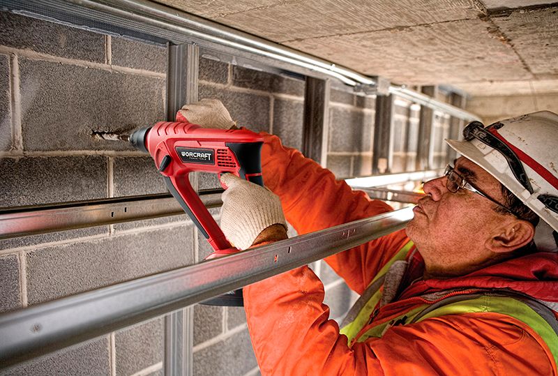 Рабочий использует аккумуляторный перфоратор WORCRAFT CRH-S20LiE для сверления в потолке.