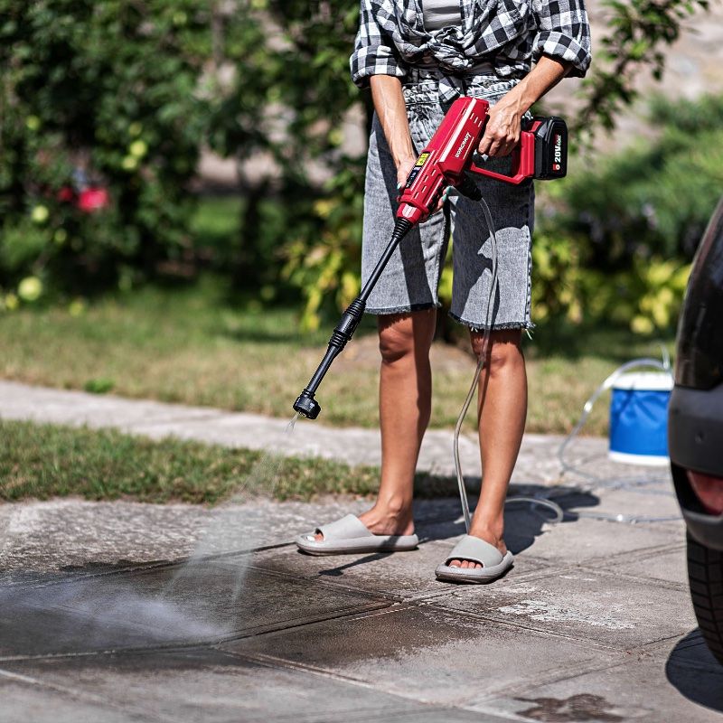 Струя воды под высоким давлением от WORCRAFT CPC-S20LiC очищает тротуар.