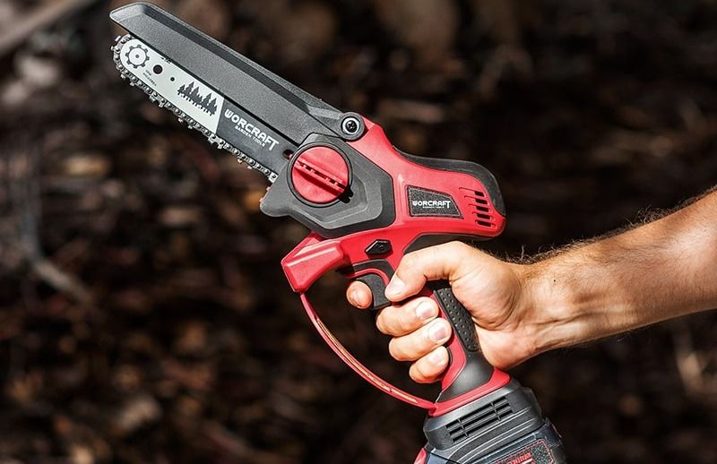 Аккумуляторная цепная пила WORCRAFT в руке пользователя