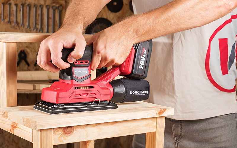 Мастер шлифует деревянный табурет шлифмашиной WORCRAFT CFS-S20Li в мастерской.