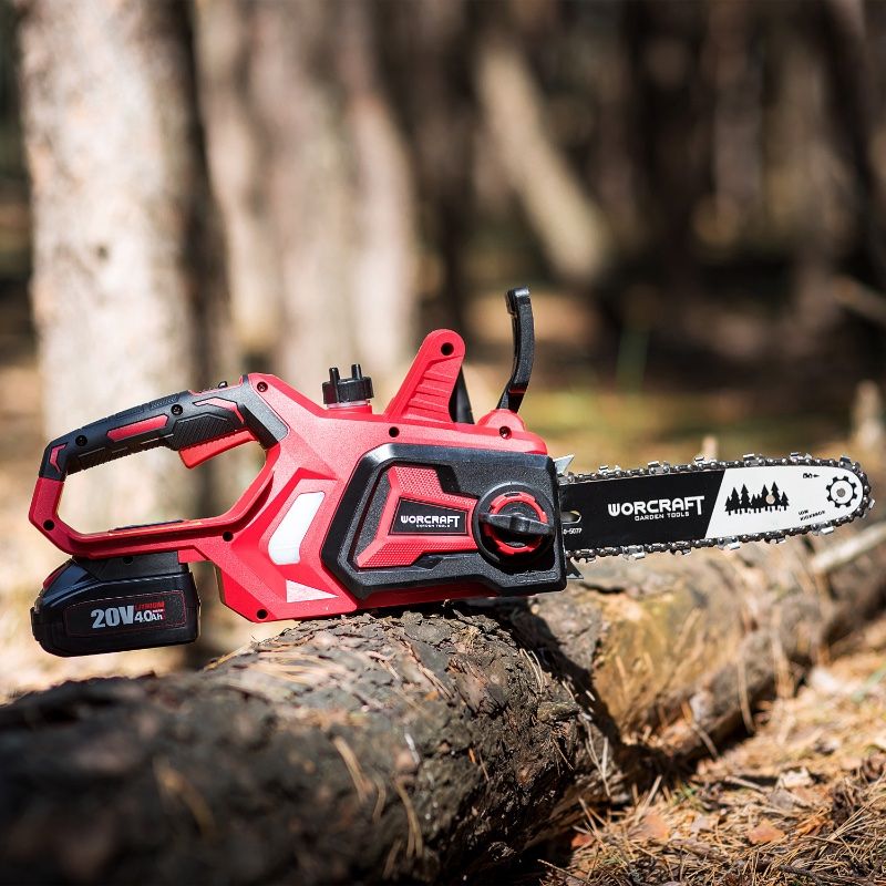Акумуляторна пилка WORCRAFT CGC-S20LiA лежить на спиляній деревині в лісі.