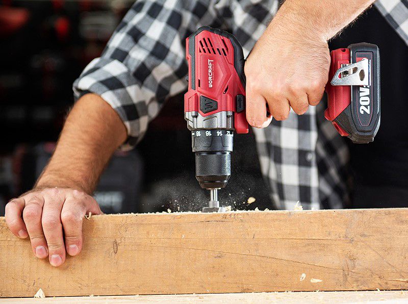 Аккумуляторный шуруповерт WORCRAFT CD-S20LiWB сверлит отверстие в деревянной доске.