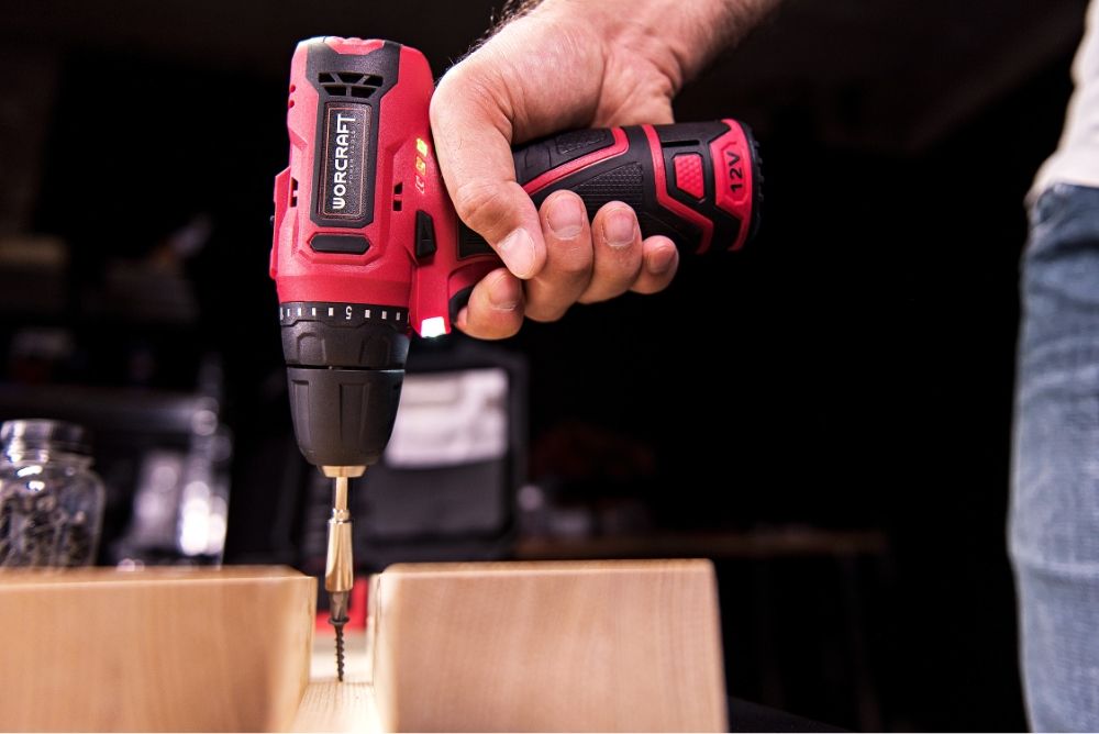 Аккумуляторный шуруповёрт WORCRAFT CD-12LiA в процессе закручивания самореза в доску.