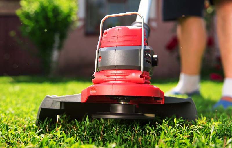 Триммер в процессе кошения травы