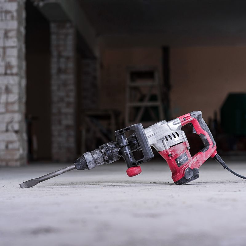 Молоток отбойный WORCRAFT DB13-15 в рабочем положении на строительной площадке.