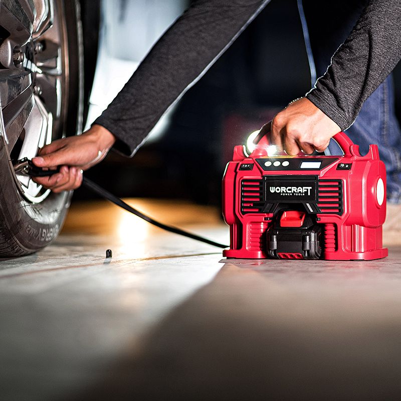 Процесс накачивания автомобильной шины аккумуляторным компрессором WORCRAFT CAC-S20LiA ночью.