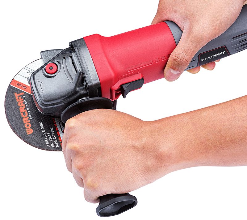 Угловая шлифмашина WORCRAFT AG08-125S в руках — вид на корпус и шлифовальный диск.