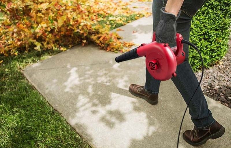 Электрический воздуходув WORCRAFT LB-400 в работе на приусадебном участке, очистка тротуара от опавших листьев.