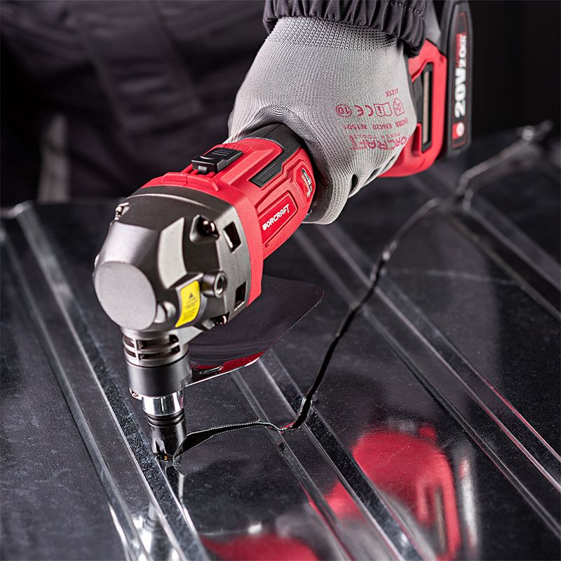 Близкий план процесса резки металла аккумуляторными высечными ножницами WORCRAFT.