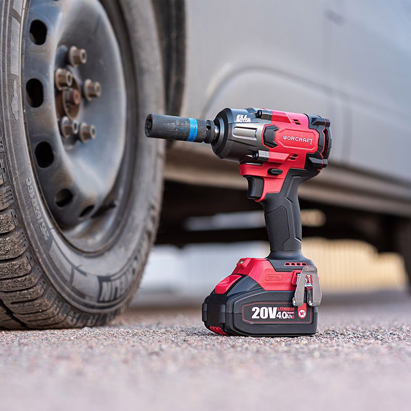 Аккумуляторный гайковерт WORCRAFT откручивает колесные гайки автомобиля.