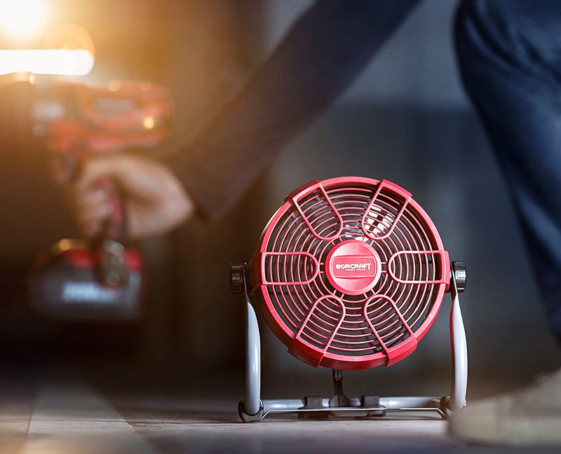 Аккумуляторный рабочий вентилятор WORCRAFT CJF-S20Li используется в помещении рядом с работающим инструментом.