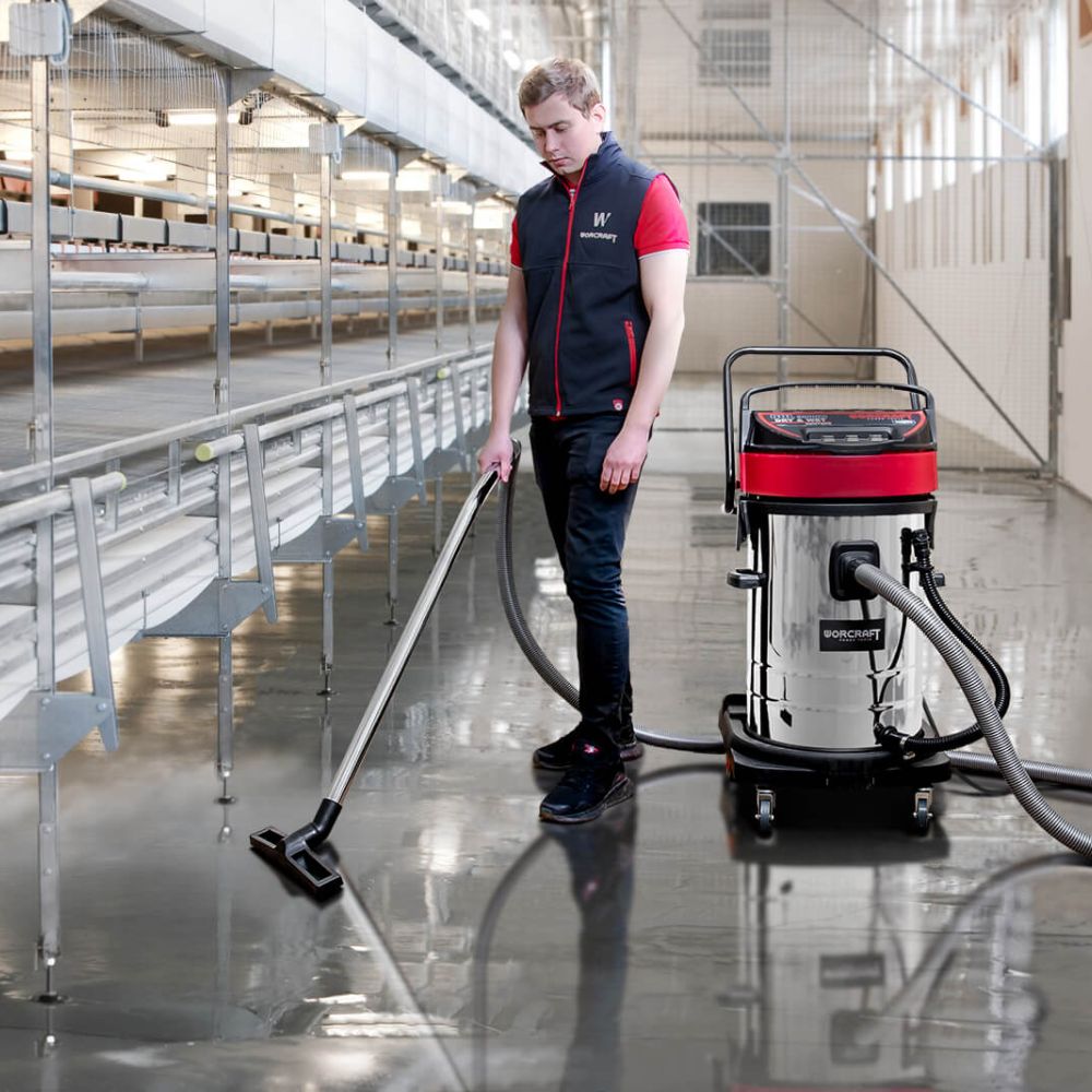 Человек убирает пол промышленным пылесосом WORCRAFT VC30-80 на объекте.