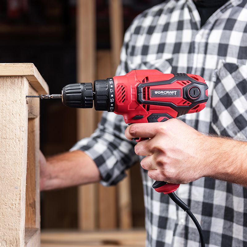 Мужчина закручивает шуруп в деревянную деталь с помощью WORCRAFT ED-400.