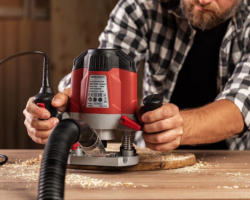 Мужчина окрашивает металлический забор с помощью электрического краскопульта WORCRAFT SG06-800.