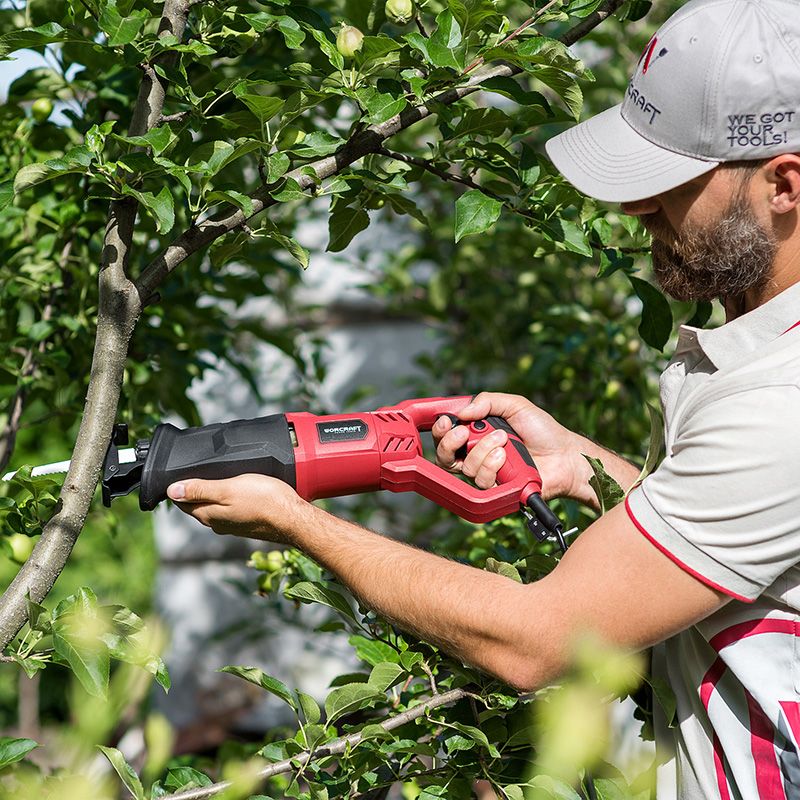 Использование сабельной пилы WORCRAFT RS07-115E для обрезки веток на дереве.