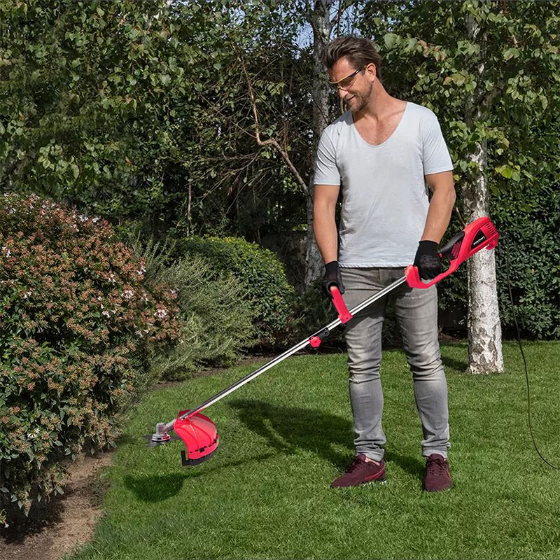 Мужчина ухаживает за садом, используя электрический триммер WORCRAFT EGT18-380.